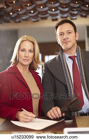Stock Photo - Couple standing at hotel front desk. Fotosearch