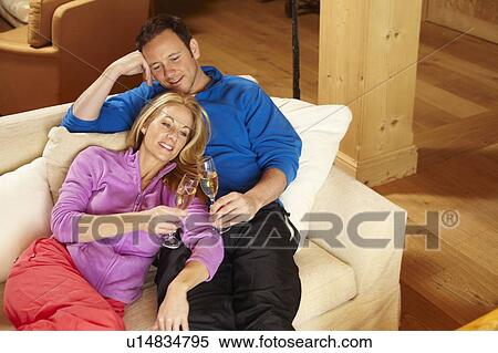 Couple toasting each other on sofa View Large Photo Image Stock Photography - Couple toasting each other on sofa. Fotosearch