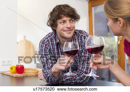 Stock Image - Couple toasting each other with wine. Fotosearch