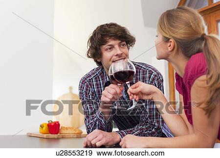 Stock Photo - Couple toasting each other with wine. Fotosearch