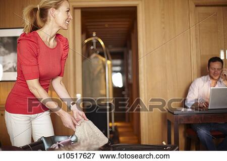 Stock Photo - Couple unpacking in hotel room. Fotosearch