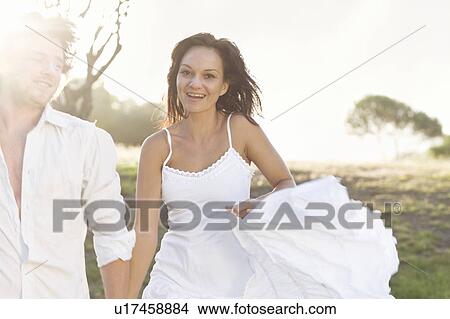 Couple walking together in field View Large Photo Image Picture - Couple walking together in field. Fotosearch
