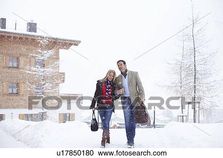Stock Image - Couple walking together in snow. Fotosearch