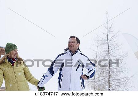 Couple walking together in snow View Large Photo Image Stock Photo - Couple walking together in snow. Fotosearch