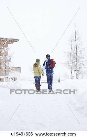 Couple walking together in snow View Large Photo Image Stock Photograph - Couple walking together in snow. Fotosearch