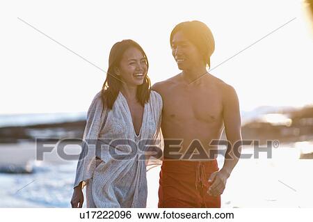 Couple walking together on beach View Large Photo Image Stock Photograph - Couple walking together on beach. Fotosearch
