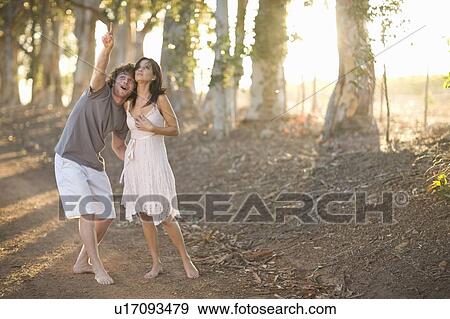 Couple walking together on dirt road View Large Photo Image Stock Photo - Couple walking together on dirt road. Fotosearch