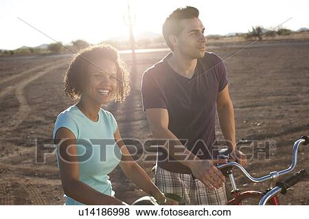 Couple with bicycles in desert landscape View Large Photo Image Stock Photo - Couple with bicycles in desert landscape. Fotosearch