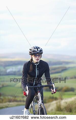 Cyclist biking on rural road View Large Photo Image Stock Image - Cyclist biking on rural road. Fotosearch