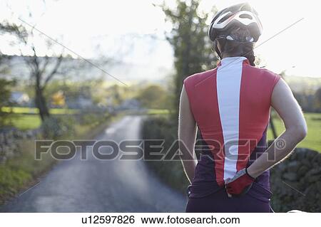 Cyclists biking on rural road View Large Photo Image Stock Photograph - Cyclists biking on rural road. Fotosearch