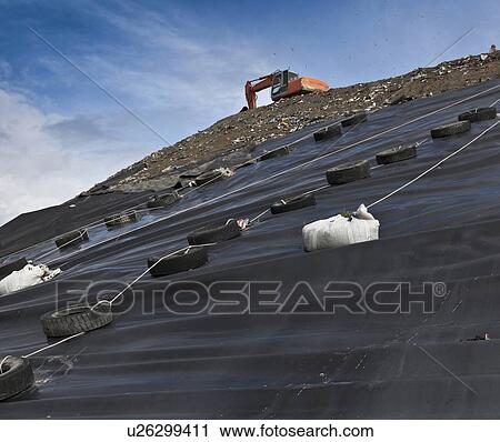 Stock Image - Digger at garbage collection center. Fotosearch