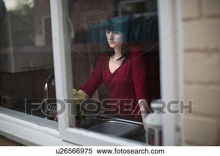 Stock Photography - Disappointed woman standing in kitchen. Fotosearch
