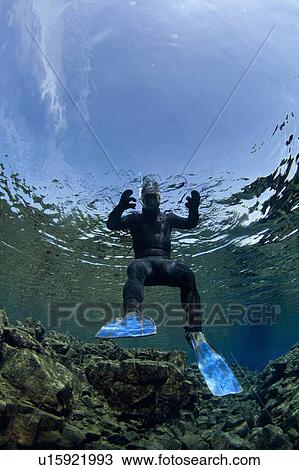 Diver swimming by rock formations View Large Photo Image Stock Image - Diver swimming by rock formations. Fotosearch