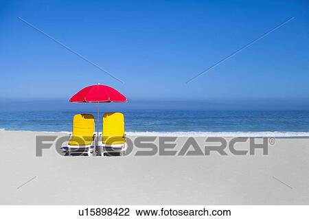 Empty lawn chairs and umbrella on beach View Large Photo Image Stock Image - Empty lawn chairs and umbrella on beach. Fotosearch