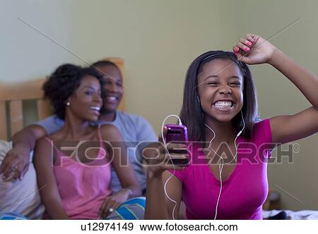Family relaxing together on bed View Large Photo Image Stock Photo - Family relaxing together on bed. Fotosearch
