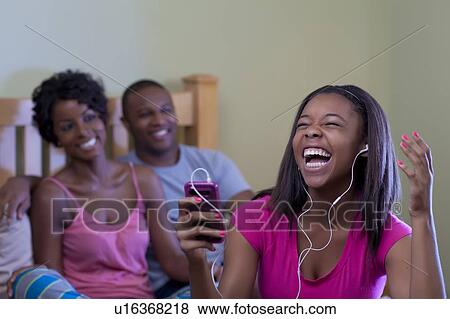 Stock Photo - Family relaxing together on bed. Fotosearch