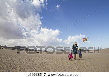 Stock Photo - Family walking together on beach. Fotosearch