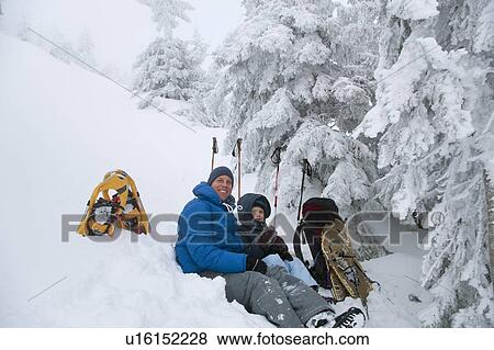 Stock Photo - Father and son resting while snowshoeing. Fotosearch