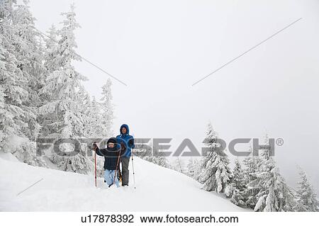 Father and son snowshoeing on hillside View Large Photo Image Stock Image - Father and son snowshoeing on hillside. Fotosearch