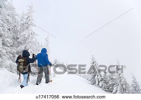 Father and son snowshoeing on hillside View Large Photo Image Stock Photograph - Father and son snowshoeing on hillside. Fotosearch