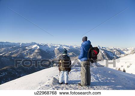 Father and son surveying snowy landscape View Large Photo Image Stock Photo - Father and son surveying snowy landscape. Fotosearch