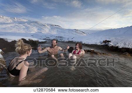 Friends relaxing in glacial hot spring View Large Photo Image Picture - Friends relaxing in glacial hot spring. Fotosearch
