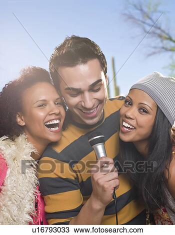Friends singing together outdoors View Large Photo Image Stock Image - Friends singing together outdoors. Fotosearch