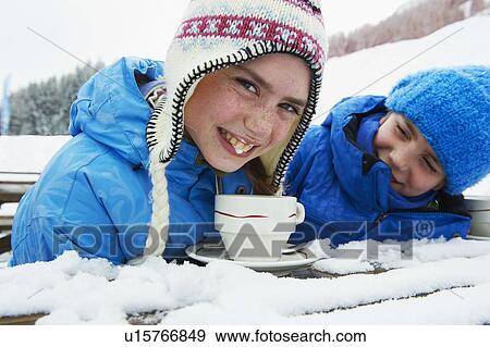 Stock Photo - Girl drinking hot chocolate in snow. Fotosearch