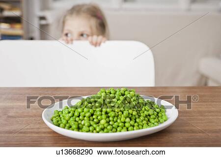 Girl hiding from peas at table View Large Photo Image Stock Image - Girl hiding from peas at table. Fotosearch