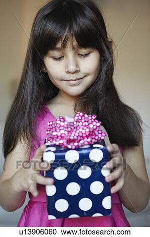 Girl holding wrapped gift View Large Photo Image Stock Image - Girl holding wrapped gift. Fotosearch