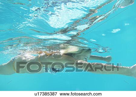 Girl in bikini swimming in pool View Large Photo Image Stock Photo - Girl in bikini swimming in pool. Fotosearch