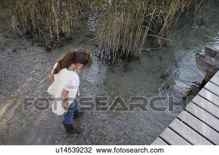 Girl in boots walking in pond View Large Photo Image Stock Image - Girl in boots walking in pond. Fotosearch