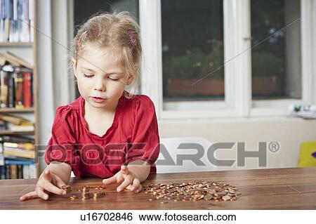 Girl playing with pennies at table View Large Photo Image Stock Photograph - Girl playing with pennies at table. Fotosearch