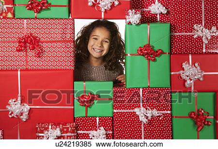 Stock Photography - Girl smiling in Christmas gift fort. Fotosearch