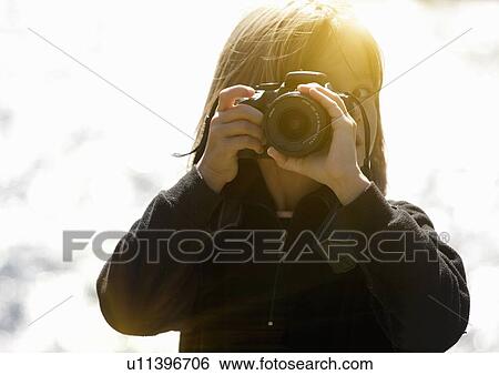 Stock Photograph - Girl taking pictures outdoors. Fotosearch