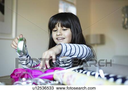 Girl wrapping presents at desk View Large Photo Image Stock Image - Girl wrapping presents at desk. Fotosearch