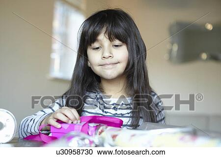 Girl wrapping presents at desk View Large Photo Image Stock Image - Girl wrapping presents at desk. Fotosearch