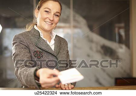 Picture - Hotel concierge with card at desk. Fotosearch