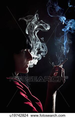 Picture - Illuminated profile of woman smoking. Fotosearch