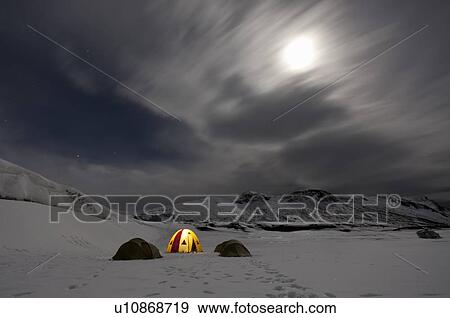 Stock Photo - Illuminated tent at glacier campsite. Fotosearch