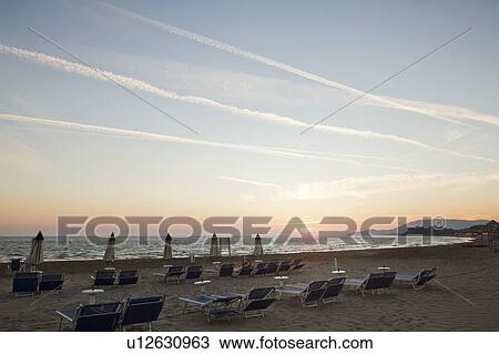 Stock Image - Lawn chairs in rows on beach. Fotosearch