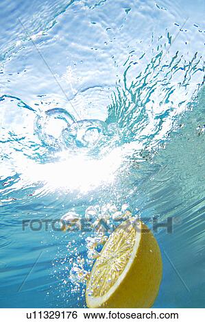 Stock Photograph - Lemon floating in swimming pool. Fotosearch