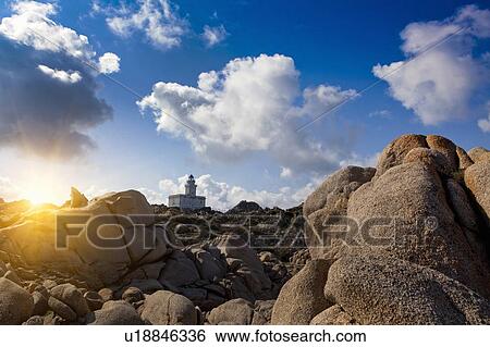 Stock Photograph - Lighthouse on rocky coastline. Fotosearch