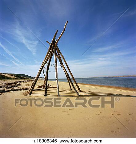 Log teepee on sandy beach View Large Photo Image Stock Photograph - Log teepee on sandy beach. Fotosearch