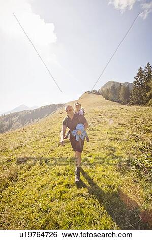 Man carrying daughter on his back View Large Photo Image Stock Photograph - Man carrying daughter on his back. Fotosearch