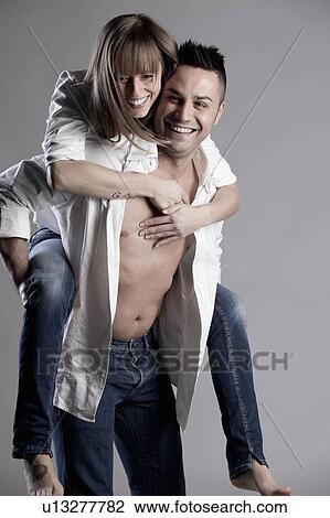 Stock Image - Man carrying girlfriend piggyback. Fotosearch