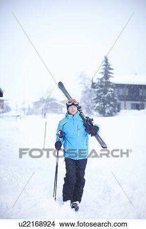 Man carrying skis and poles in snow View Large Photo Image Picture - Man carrying skis and poles in snow. Fotosearch