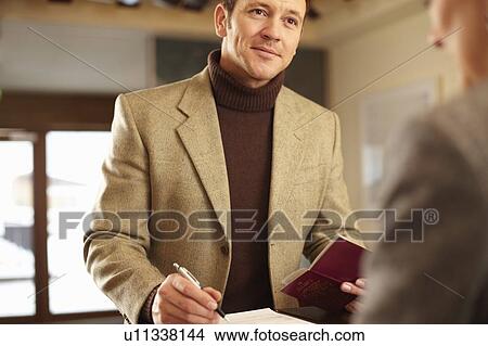 Picture - Man checking in to hotel. Fotosearch