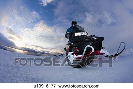 Man driving snowmobile in snowy field View Large Photo Image Stock Photo - Man driving snowmobile in snowy field. Fotosearch