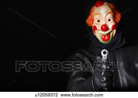 Man in clown mask pointing gun View Large Photo Image Stock Image - Man in clown mask pointing gun. Fotosearch